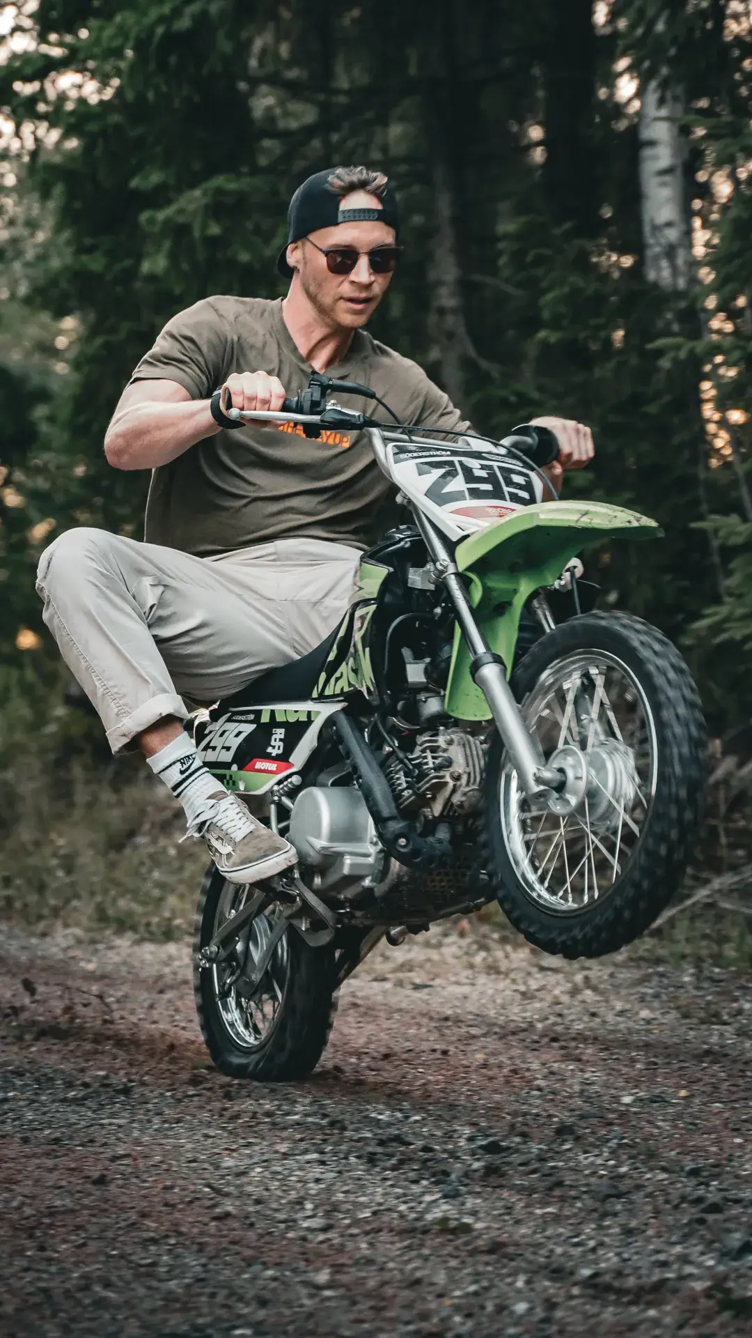 Rider popping a wheelie on a KLX110 dirtbike