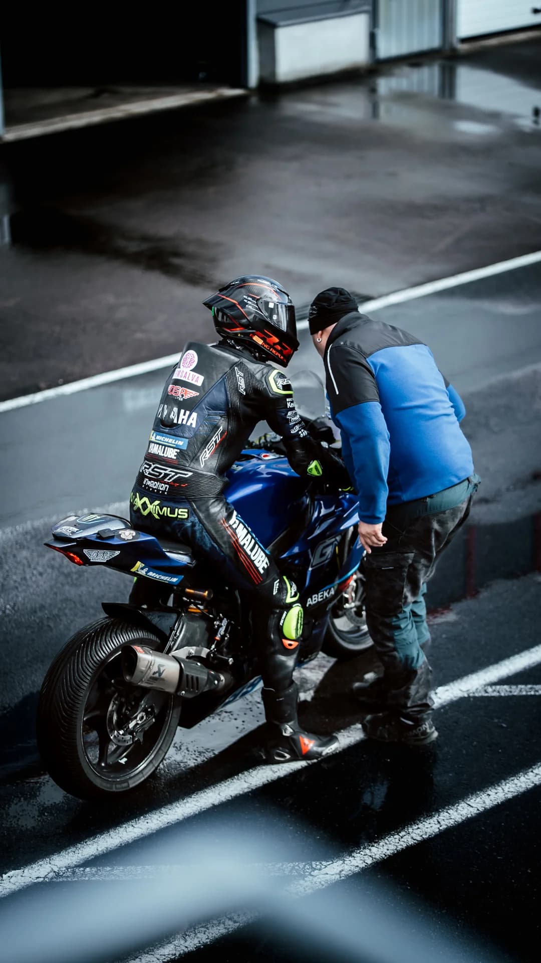 Motorcycle rider in a wet pit lane